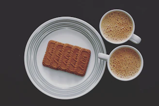 Elegant arrangement of gourmet Spanish cookies on a minimalist white plate with a red napkin.