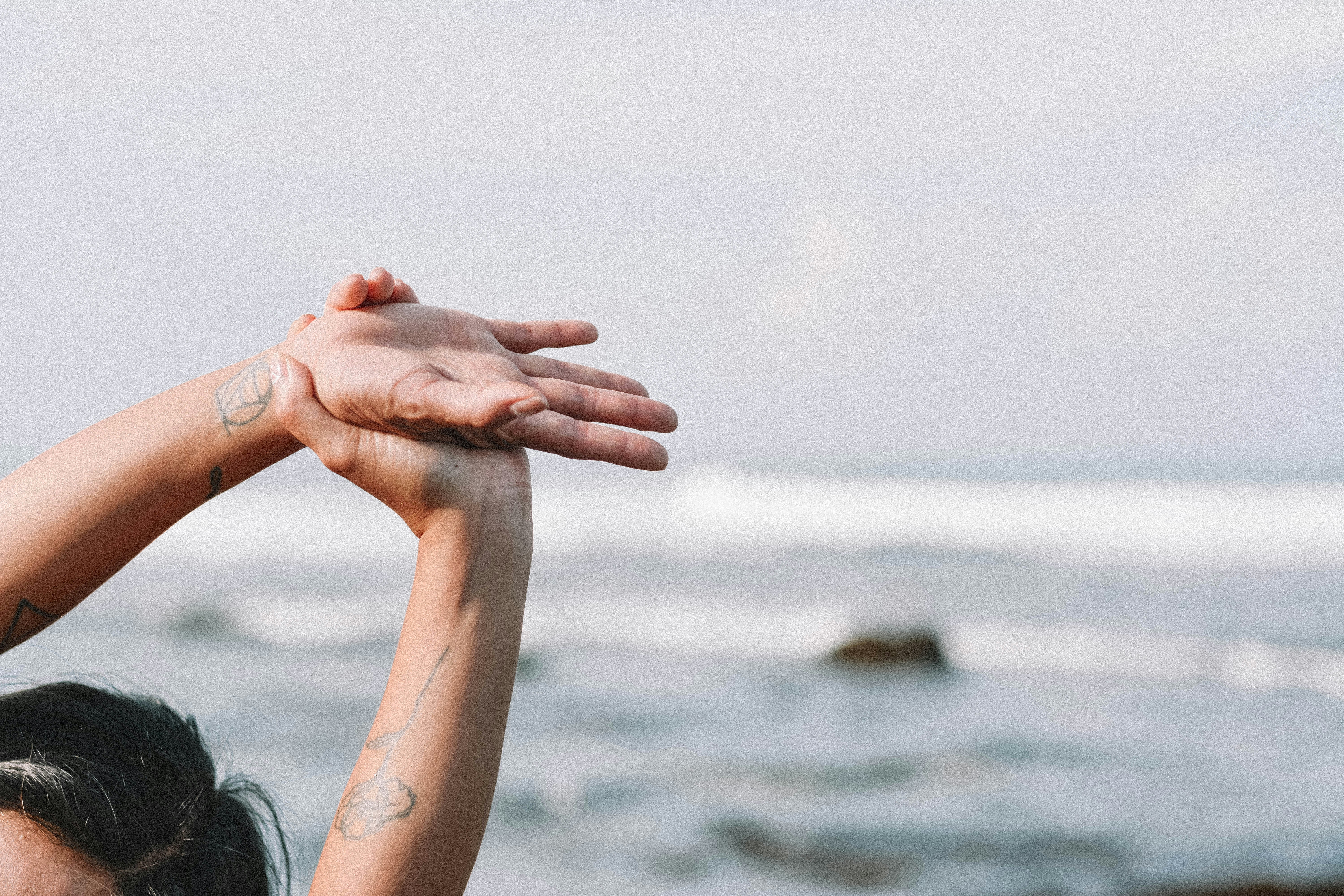 woman holding her hands on beach during daytime, Woman