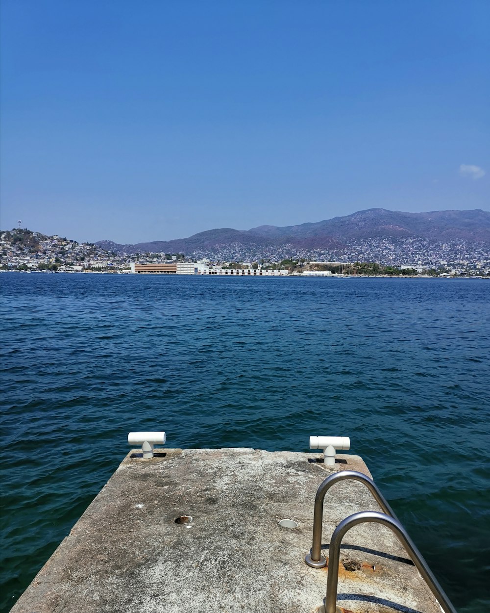 white wooden dock on blue sea under blue sky during daytime