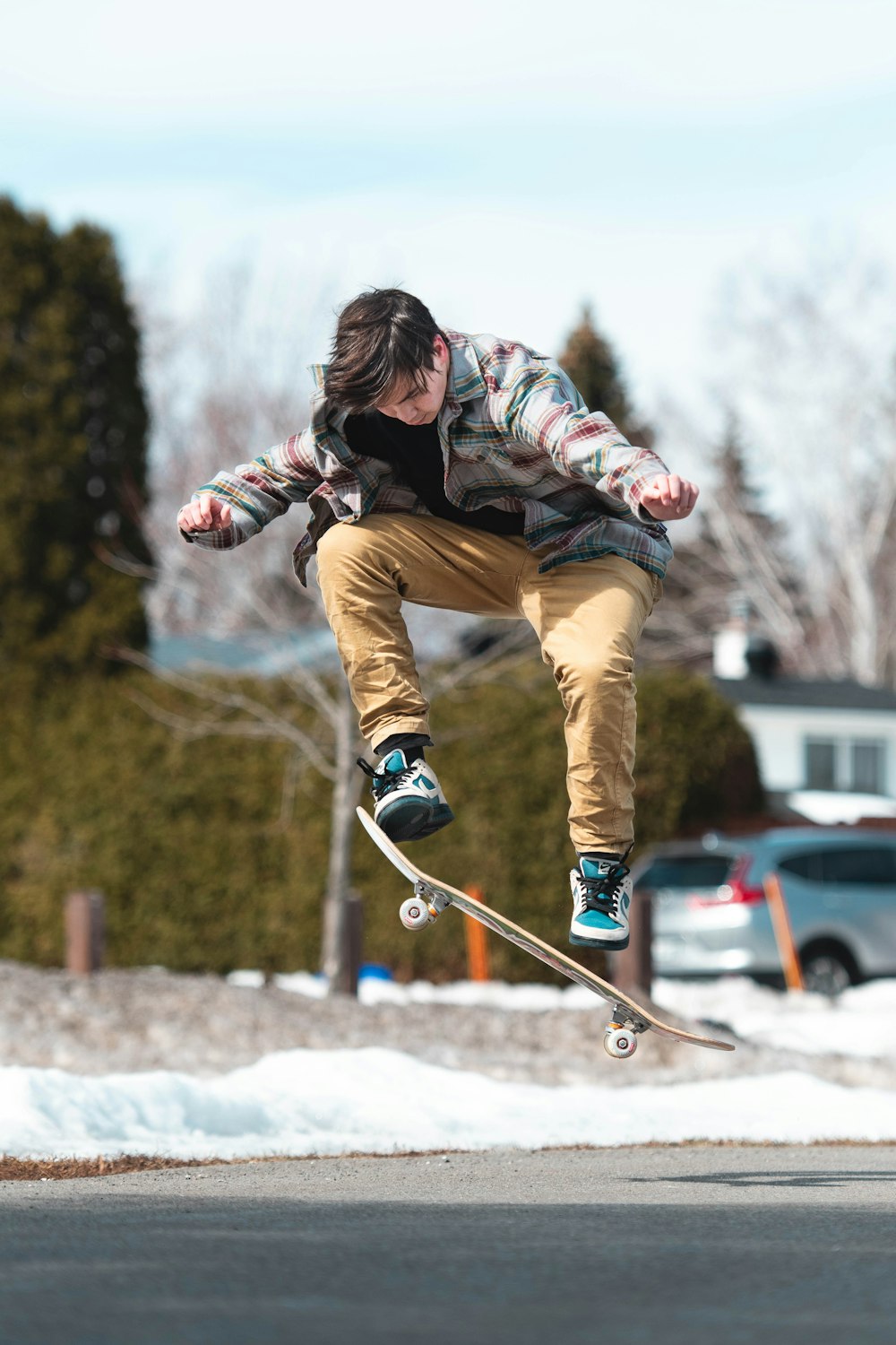 man in brown pants and black jacket riding on black and white ski blades