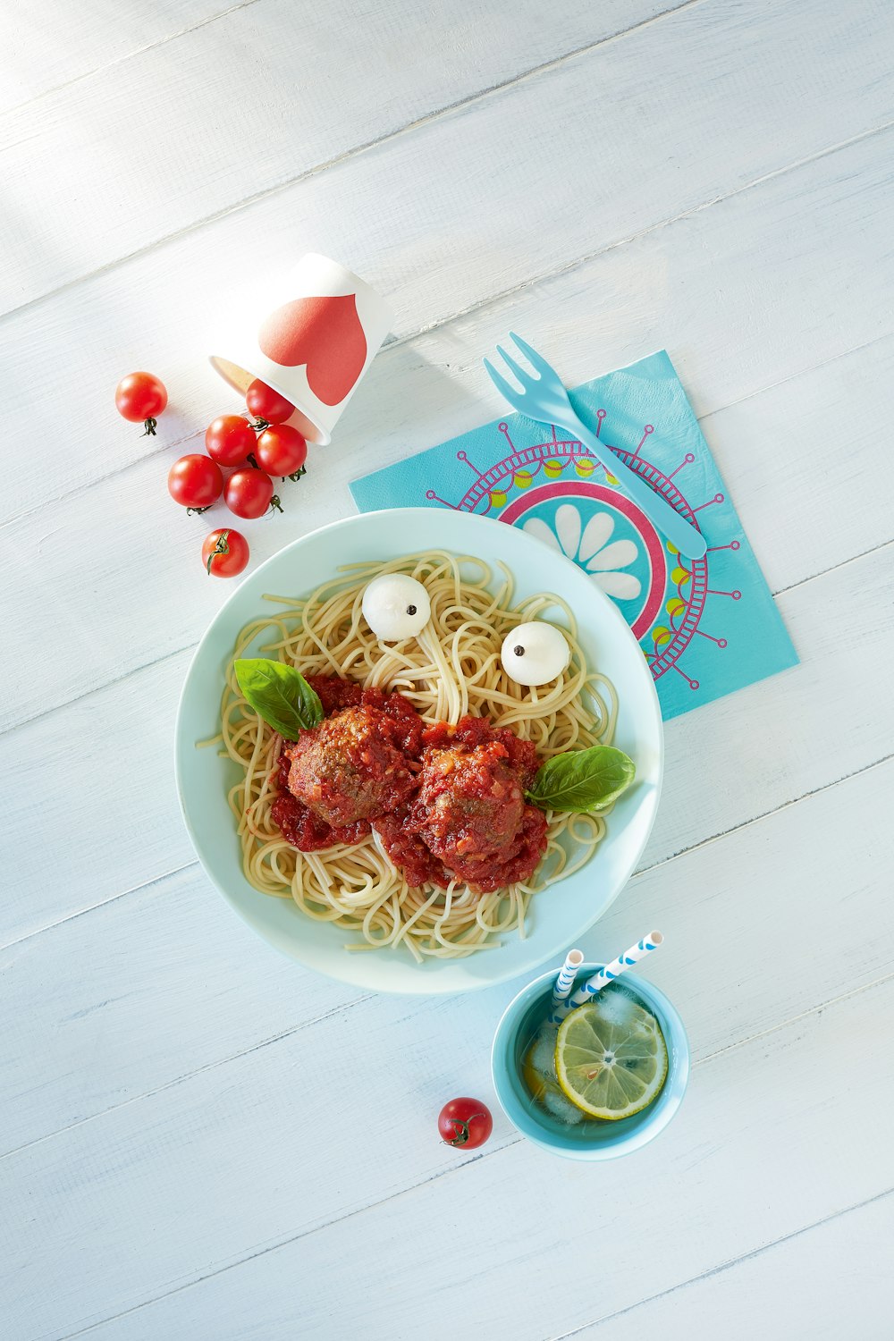 grüne und weiße Keramikschale mit Nudeln und geschnittenen Tomaten