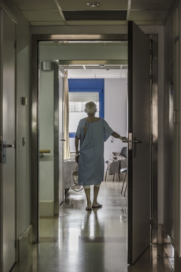 A warm, welcoming nurse assisting a patient in a bright, modern hospital corridor filled with natural light.