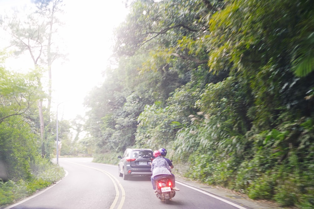 a couple of people riding on the back of a motorcycle