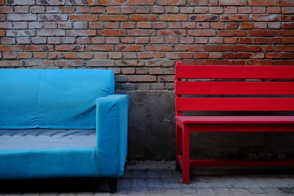 blue padded brown wooden chair beside brown brick wall