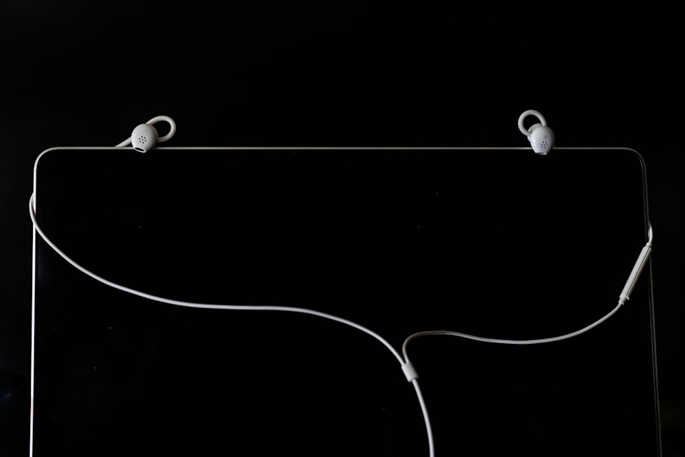 white earbuds on black surface