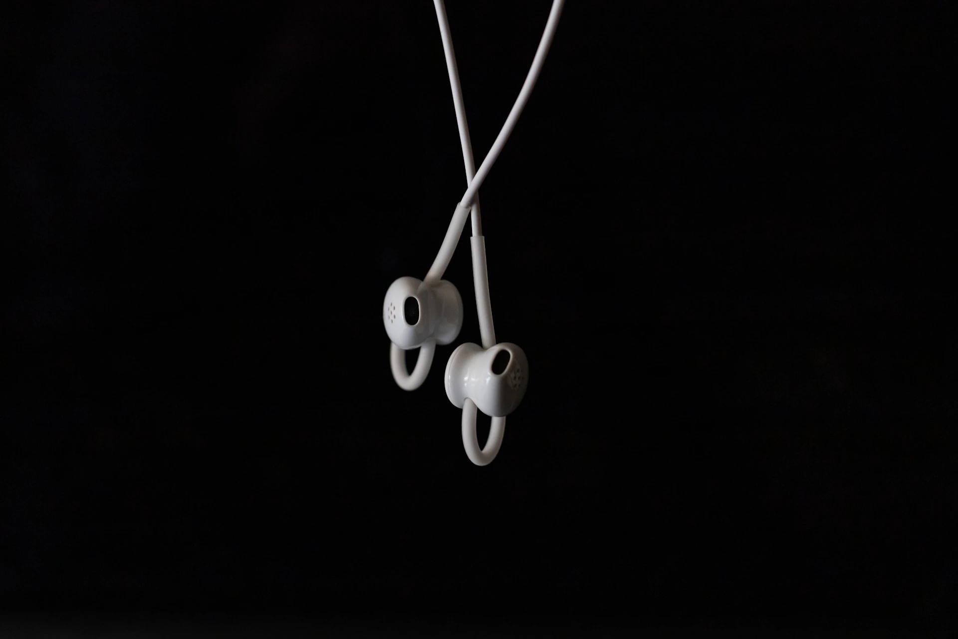white earbuds on black background