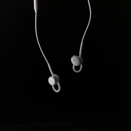 white earbuds on white surface
