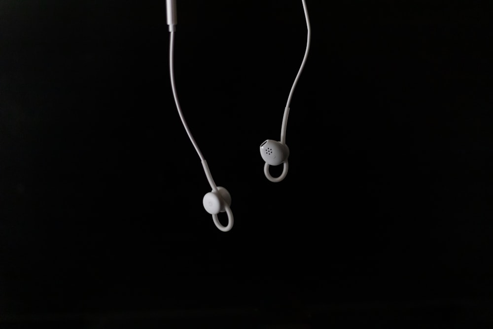 white earbuds on white surface