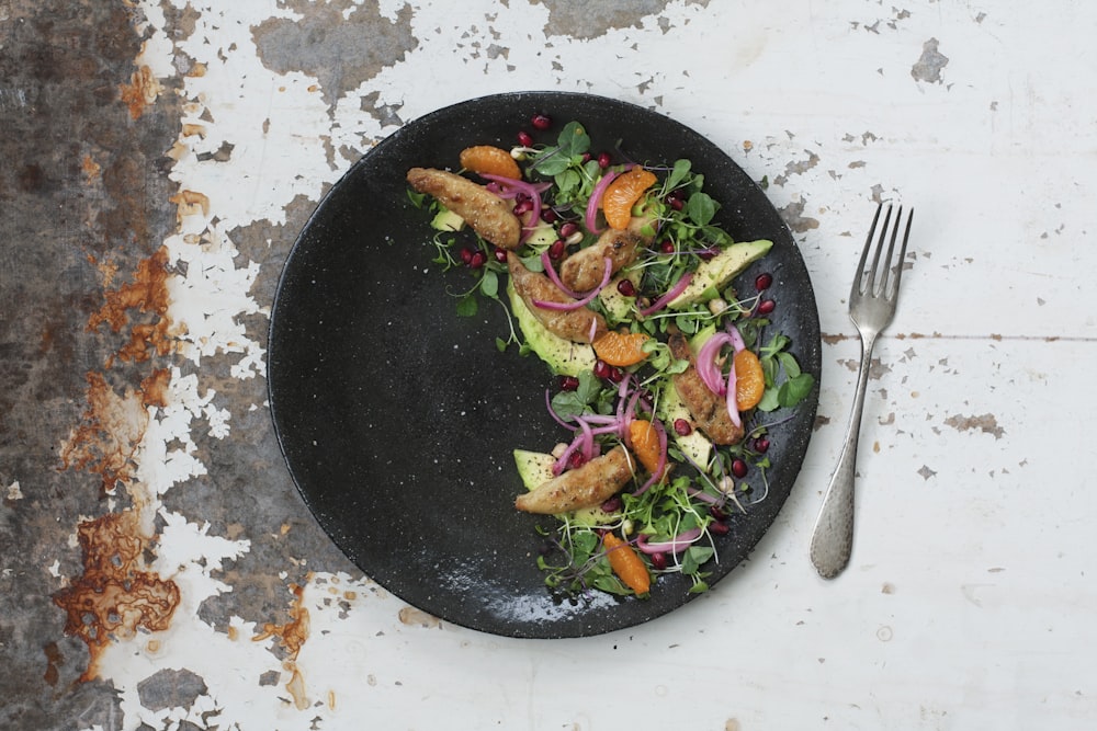 vegetable salad on black plate