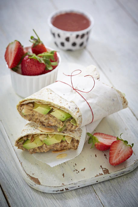 sliced bread with cheese and strawberries on white paper towel