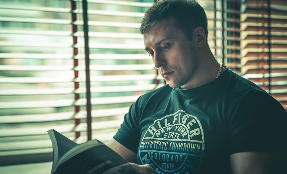 man in black and white crew neck shirt reading book