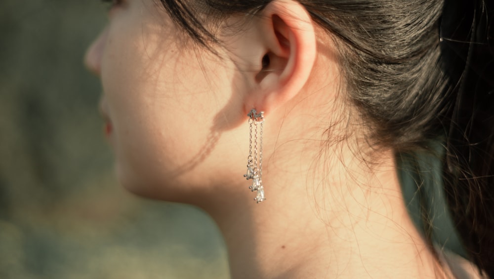 Femme portant une boucle d’oreille en diamant argenté