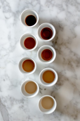 An array of colorful coffee cups on a textured black surface.