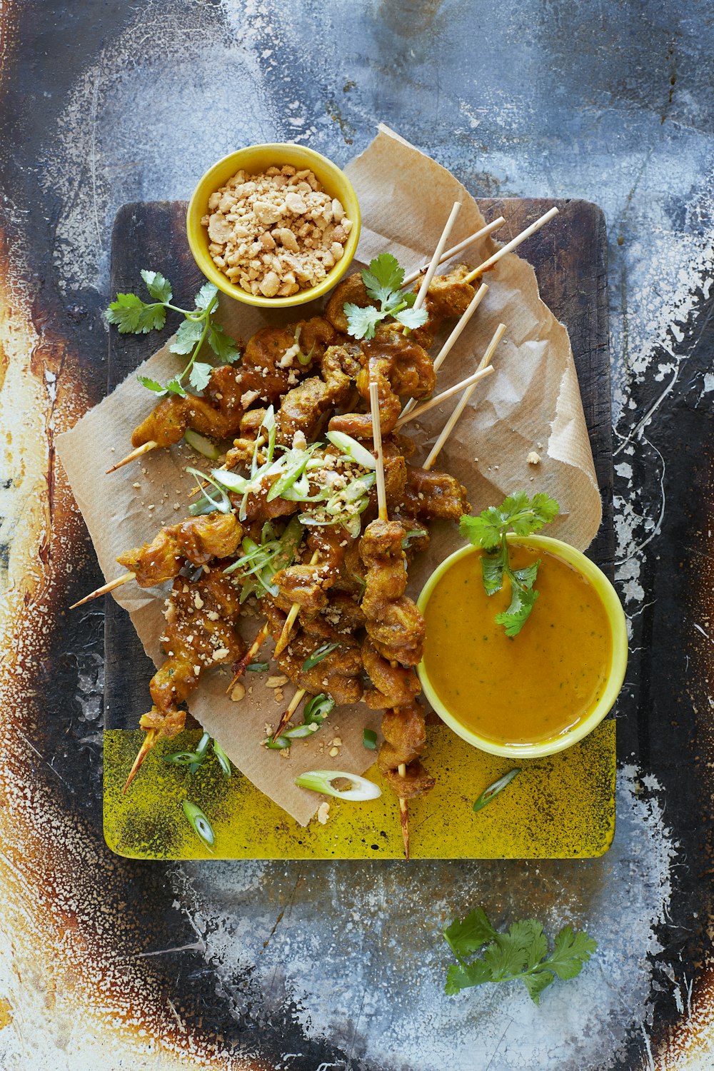 Un plato de comida con brochetas y salsa para mojar