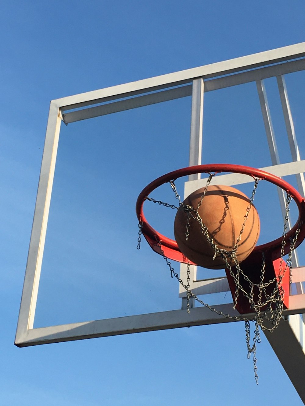 basketball on basketball hoop under blue sky during daytime