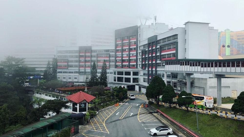 cars parked in front of white and red concrete building during daytime