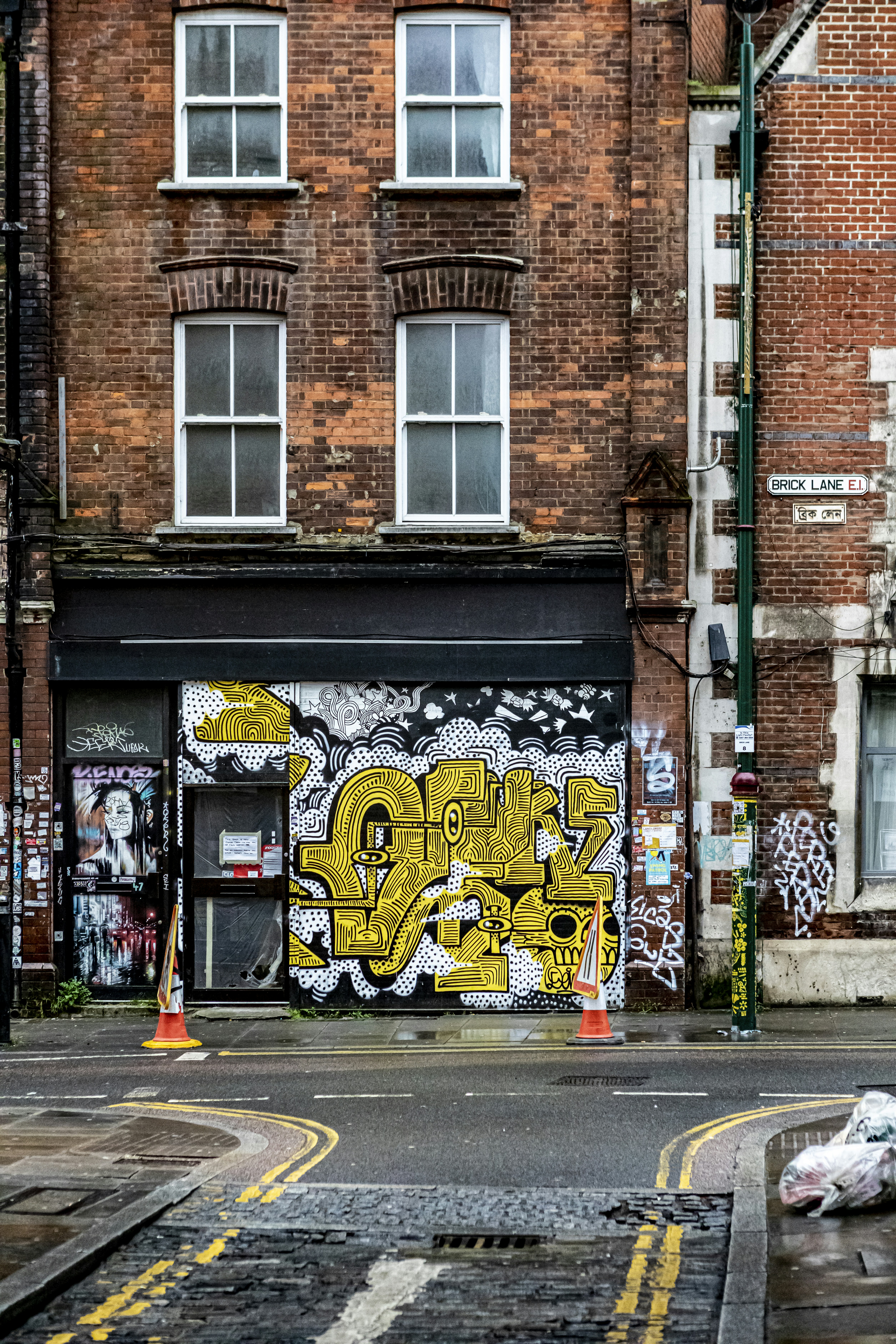 Brick Lane, Shoreditch, London, UK. January 2020. Street art, shops, graffiti, paintings, posters on the walls of old brick buildings in a historic location in England.