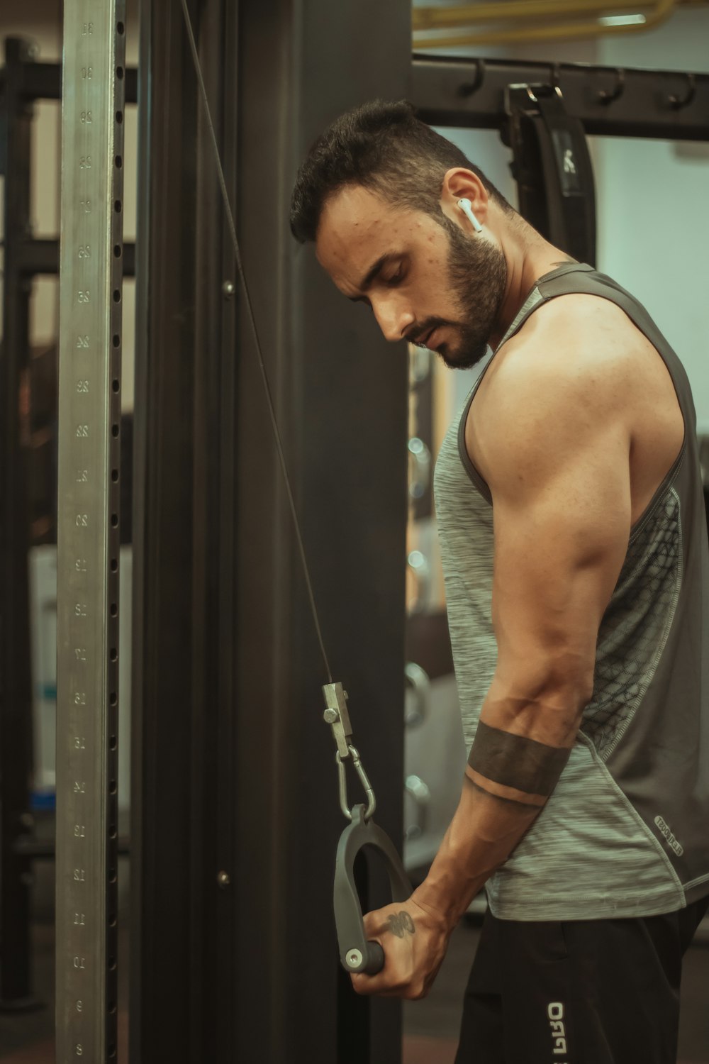 man in gray tank top holding black metal door