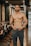 topless man in blue shorts standing on wooden floor