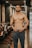 topless man in blue shorts standing on wooden floor