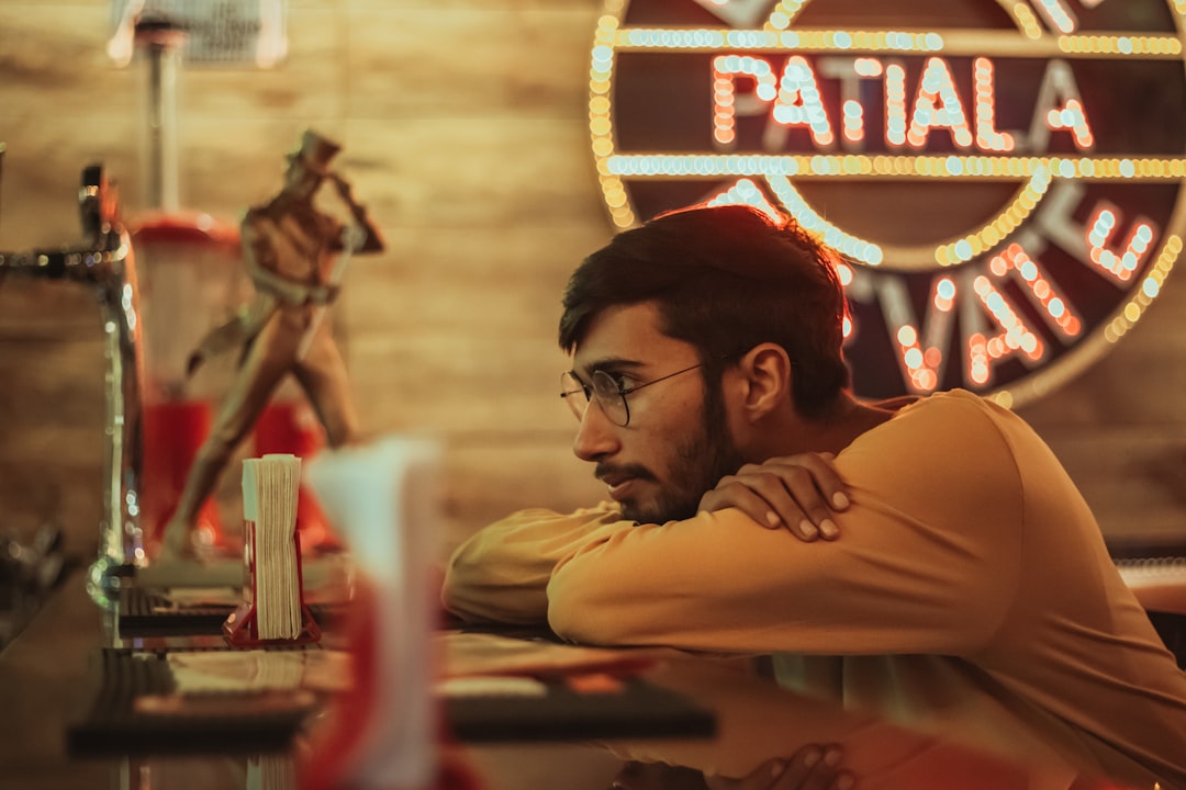 man in brown shirt wearing black framed eyeglasses