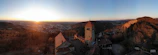 Scenic view of a European castle hotel perched on a hill at sunset.