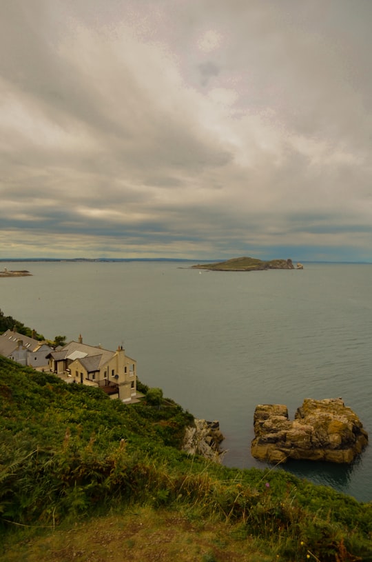 white and brown concrete building near body of water during daytime in Howth Ireland