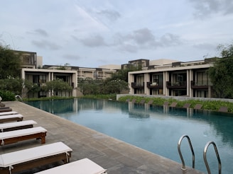 brown wooden bench beside swimming pool during daytime
