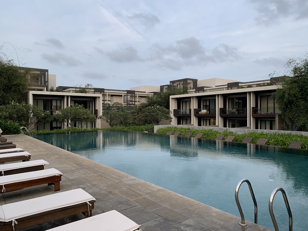 banc en bois brun à côté de la piscine pendant la journée