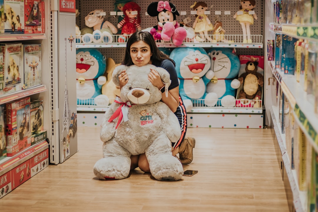 girl in white and black dress holding white bear plush toy