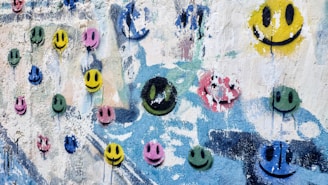 Playful mix of bright yellow and turquoise nails with tiny smiley face accents.