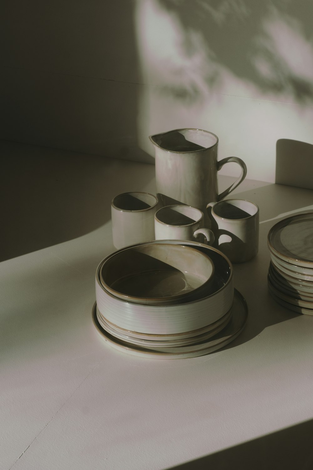 white and black ceramic mugs on white table