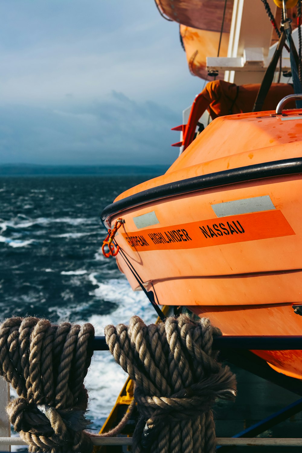 orange and white boat on sea during daytime