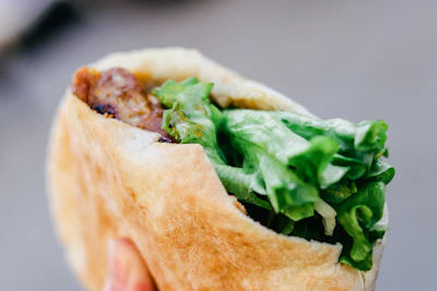 Close-up of a juicy beef kabob wrapped in lavash with cilantro and onions.