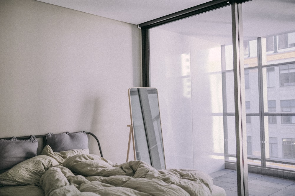 white bed linen near white wall