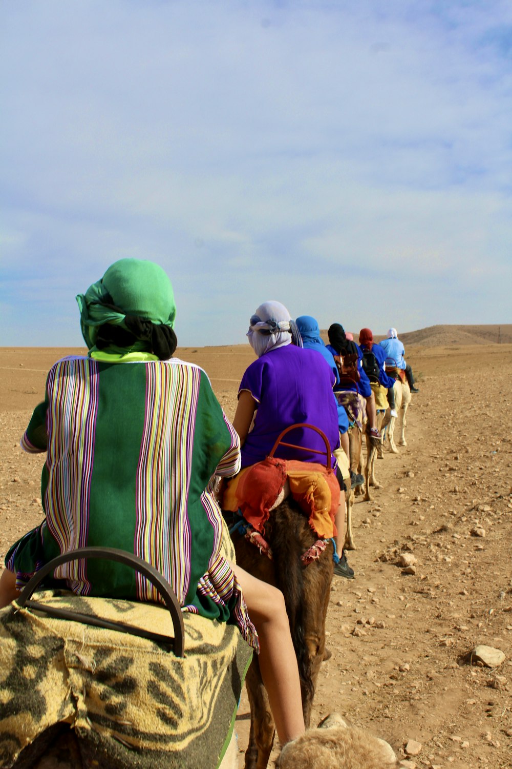 people riding horse on brown sand during daytime