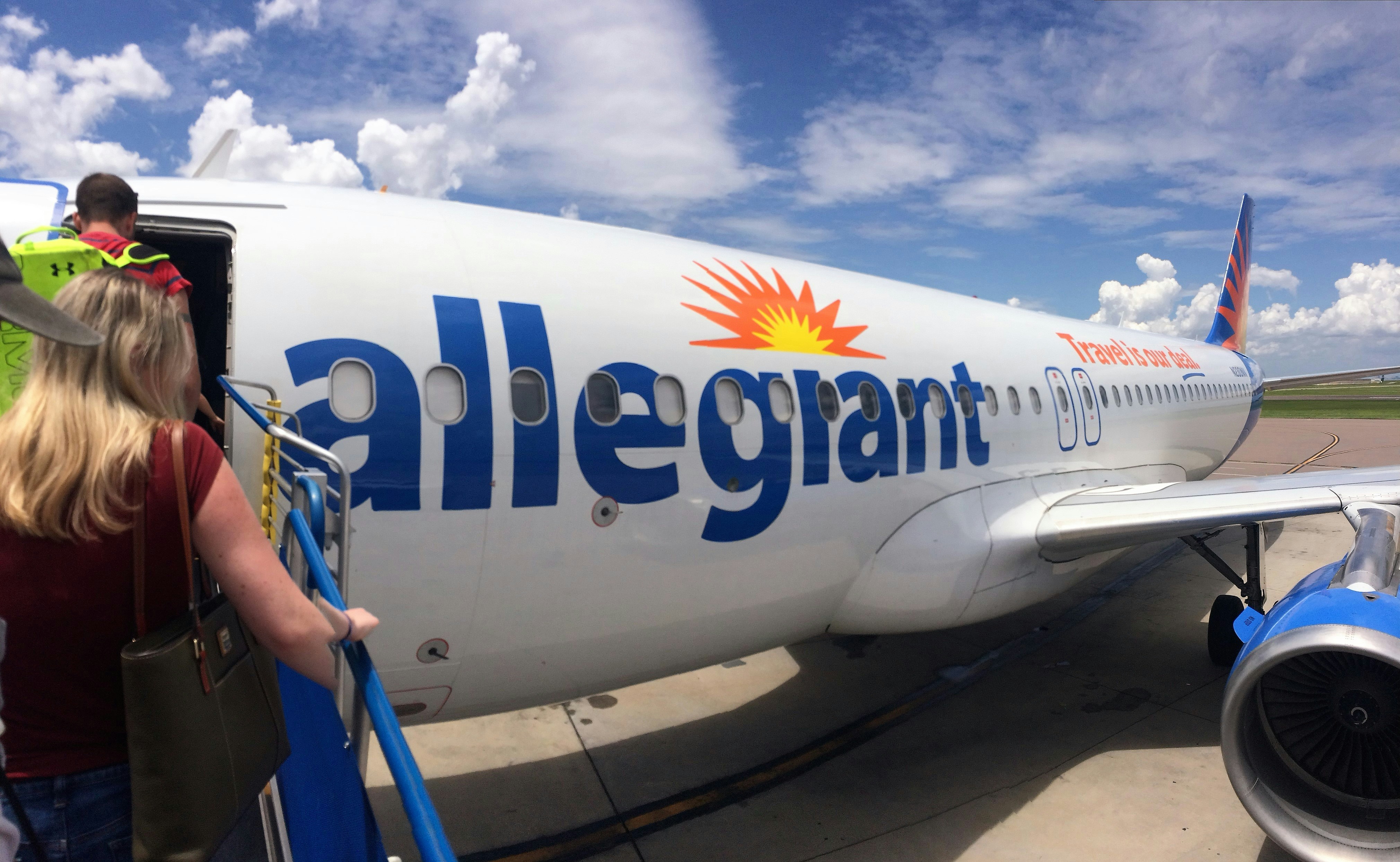 White and blue airplane under white clouds and blue sky during daytime