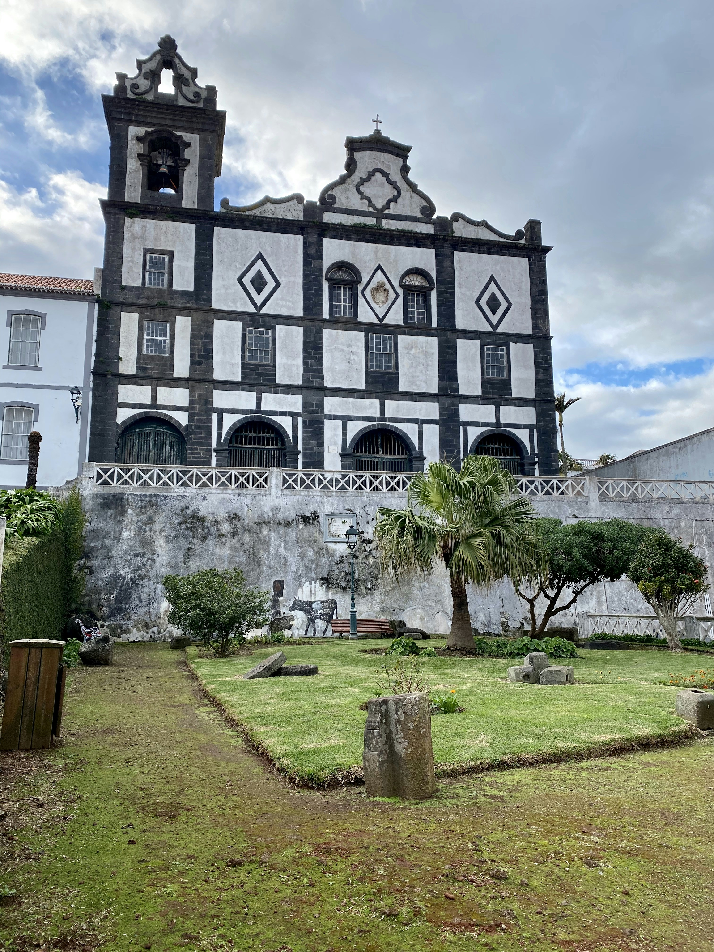 Champ d’herbe verte près d’un bâtiment en béton blanc pendant la journée