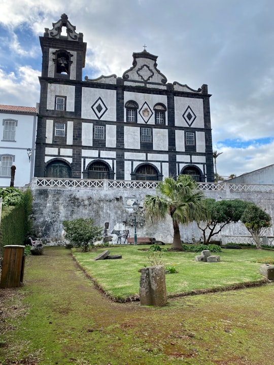 green grass field near white concrete building during daytime in Horta, Azores Portugal