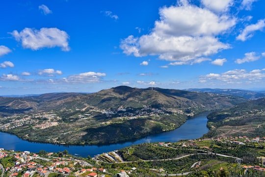 aerial view of green mountains and lake under blue sky during daytime in Castelo de Paiva Portugal