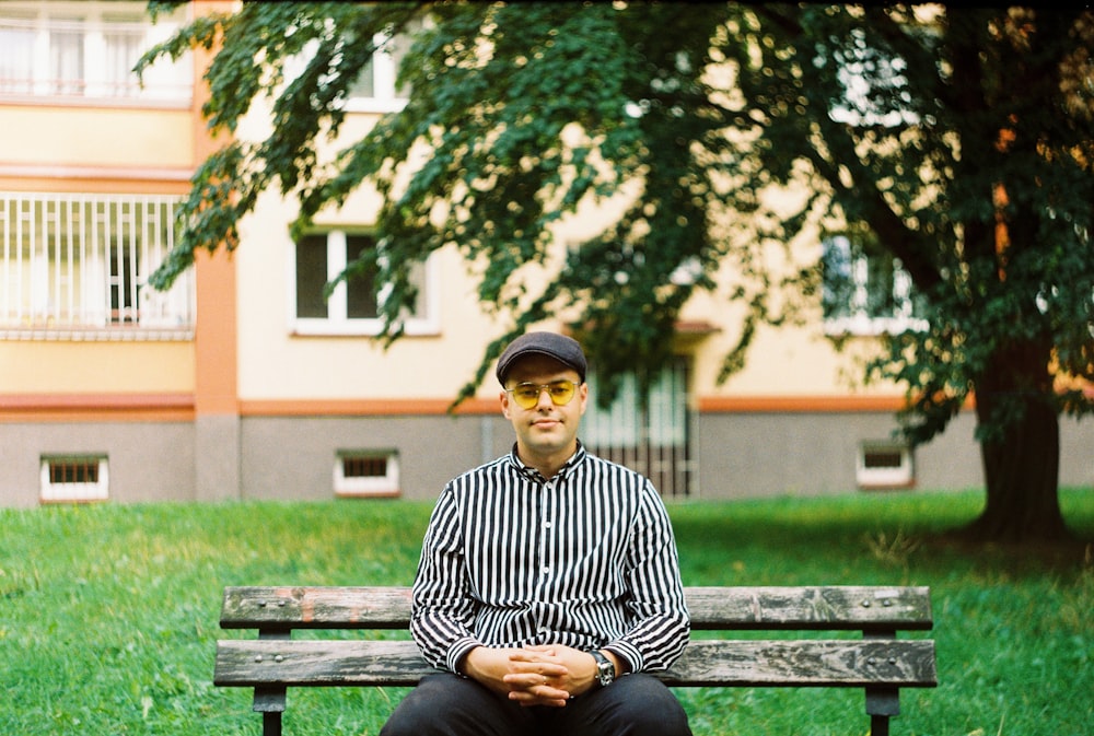 man in black and white striped long sleeve shirt sitting on bench