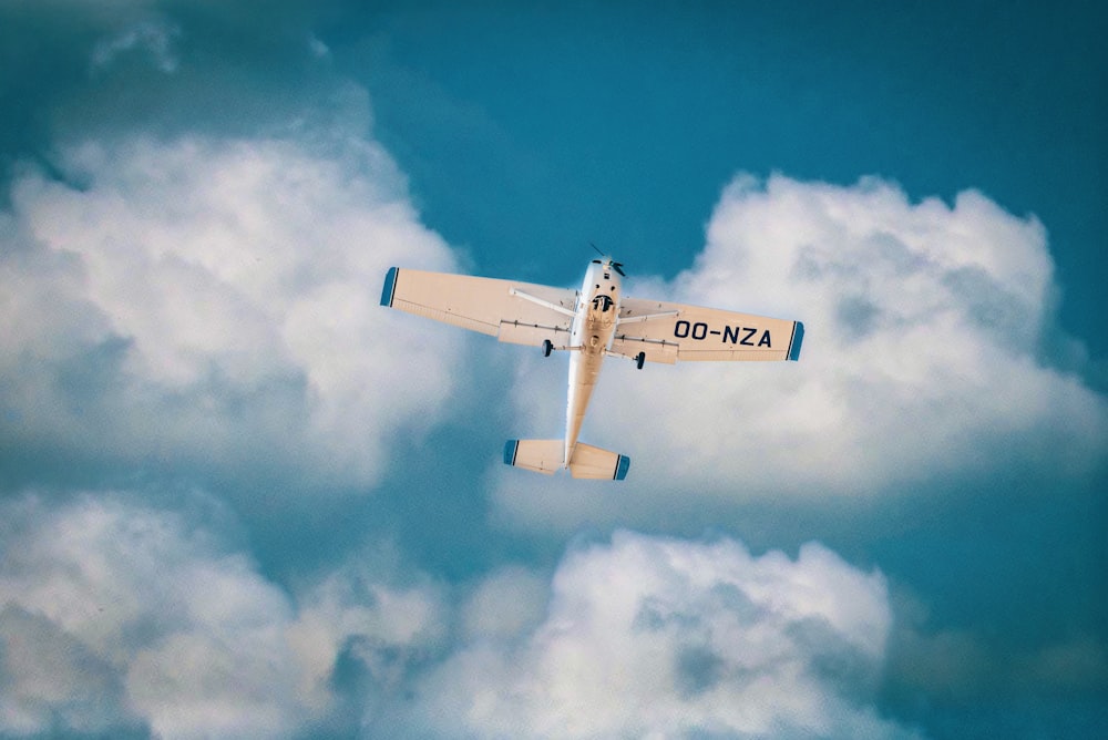 white and blue airplane under blue sky during daytime