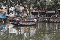 A peaceful riverside scene with traditional Vietnamese boats at sunset.