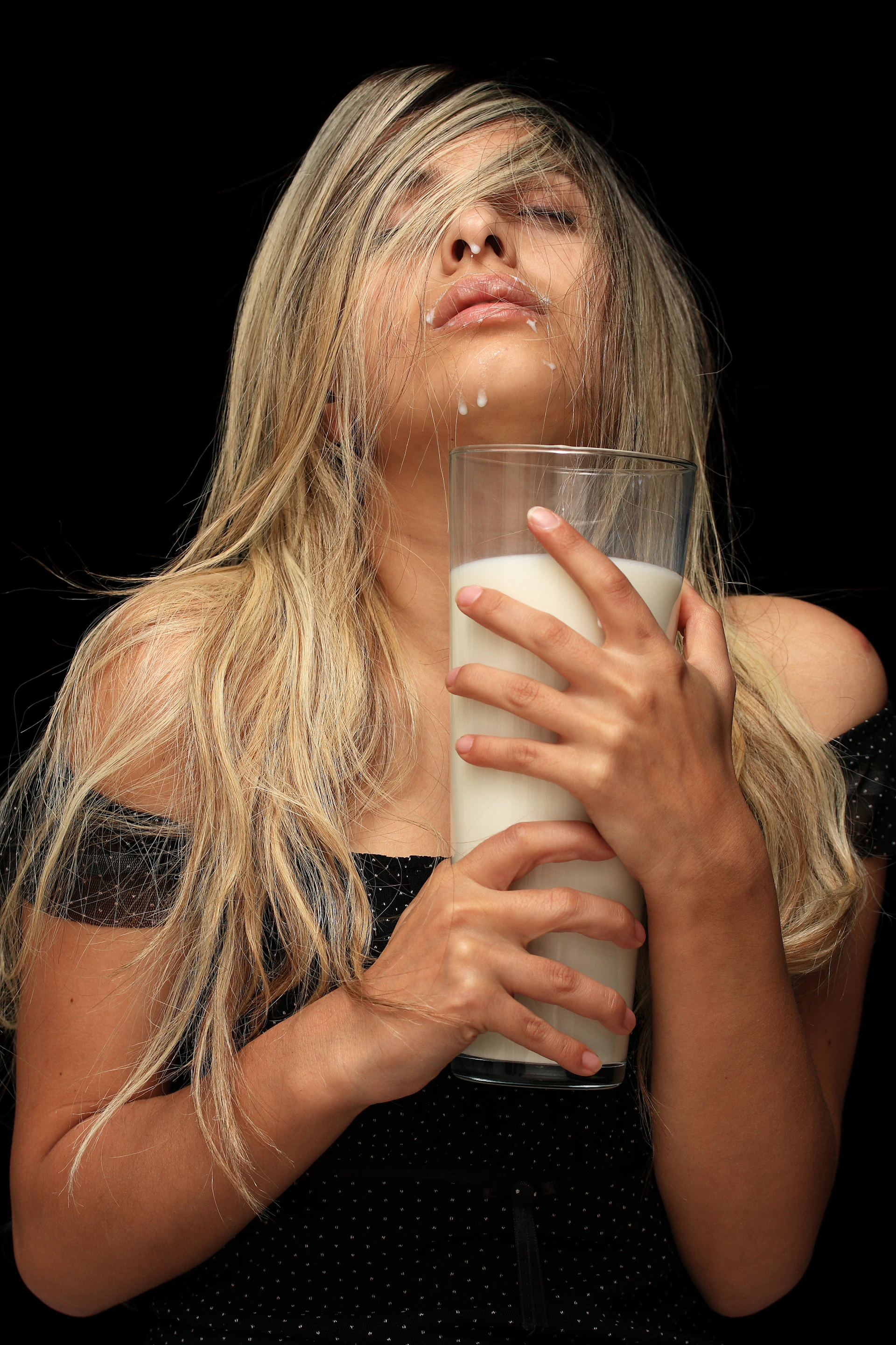 a woman is holding a glass of milk