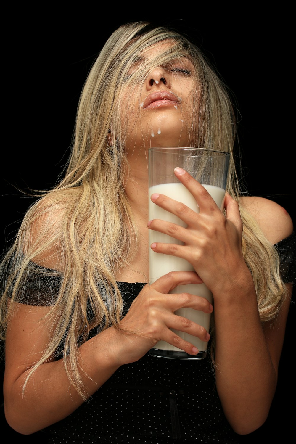 a woman is holding a glass of milk
