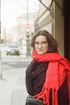 woman in red scarf and black coat wearing eyeglasses
