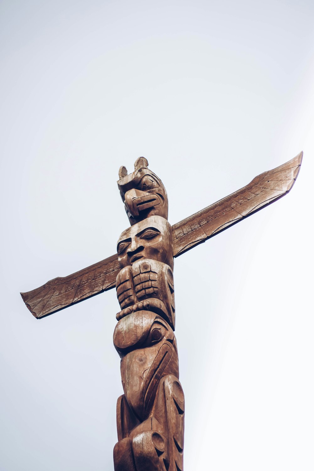 cruz de madera marrón bajo el cielo blanco durante el día