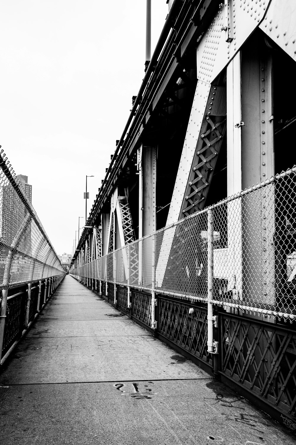 grayscale photo of bridge with metal fence