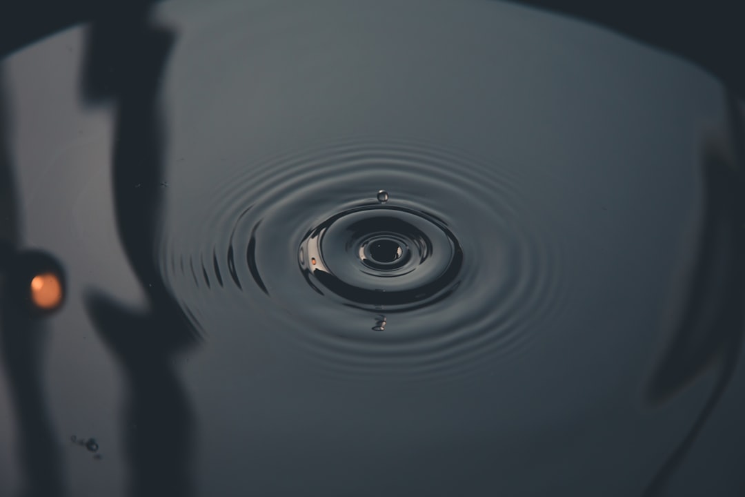 water drop in grayscale photography