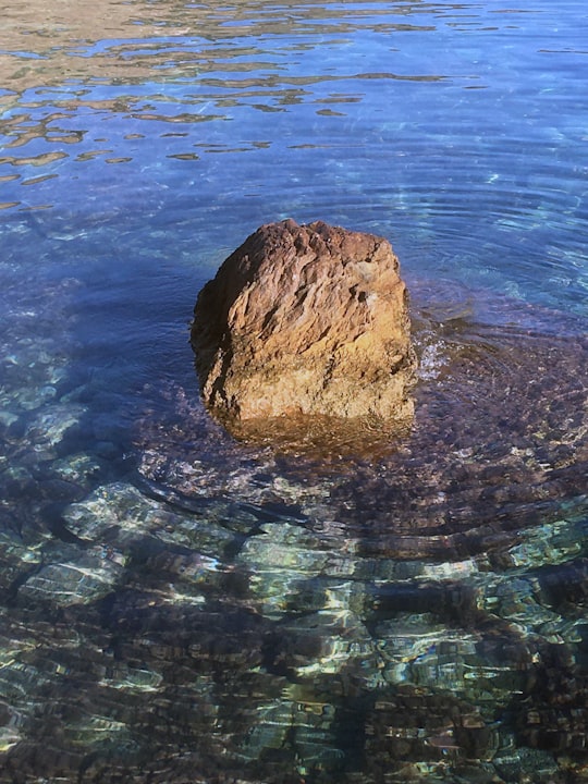 brown rock in the middle of water in Taormina Italy